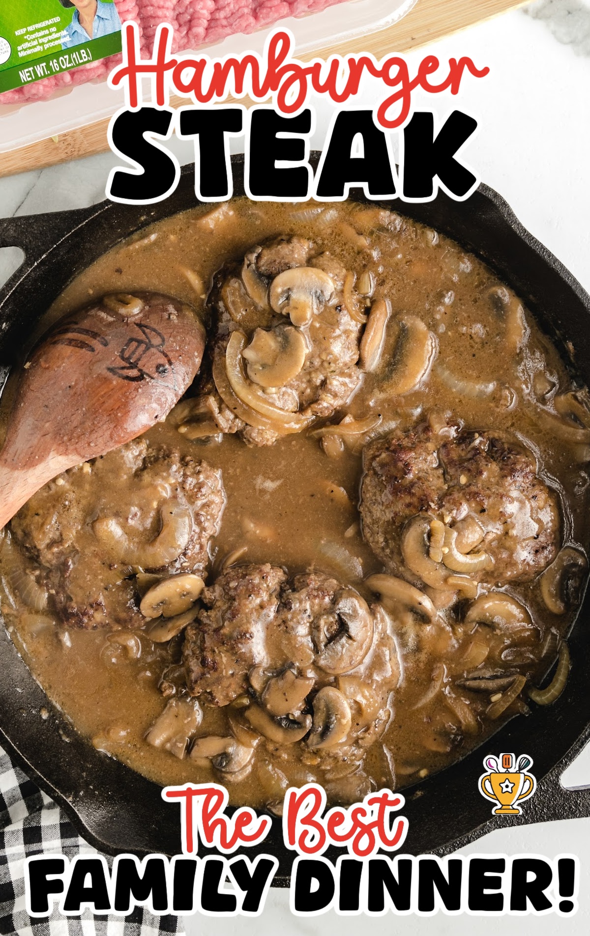 Cast iron skillet filled with hamburger steaks smothered in rich brown mushroom gravy with visible herbs and onion slices.