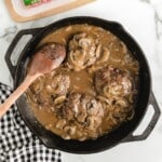 Overhead image of hamburger steaks in mushroom gravy with ingredients list, perfect for use as a printable or Pinterest recipe card.