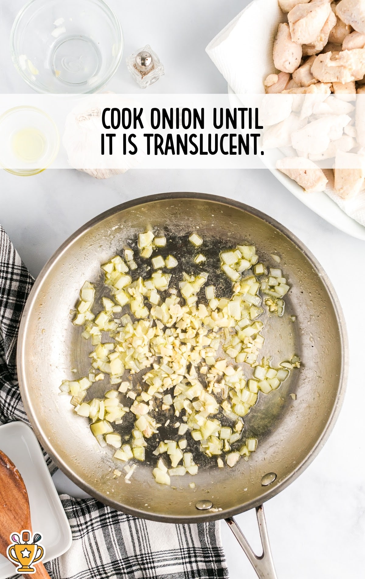 Finely chopped onions cooking in oil until translucent in a skillet for the honey garlic chicken preparation.