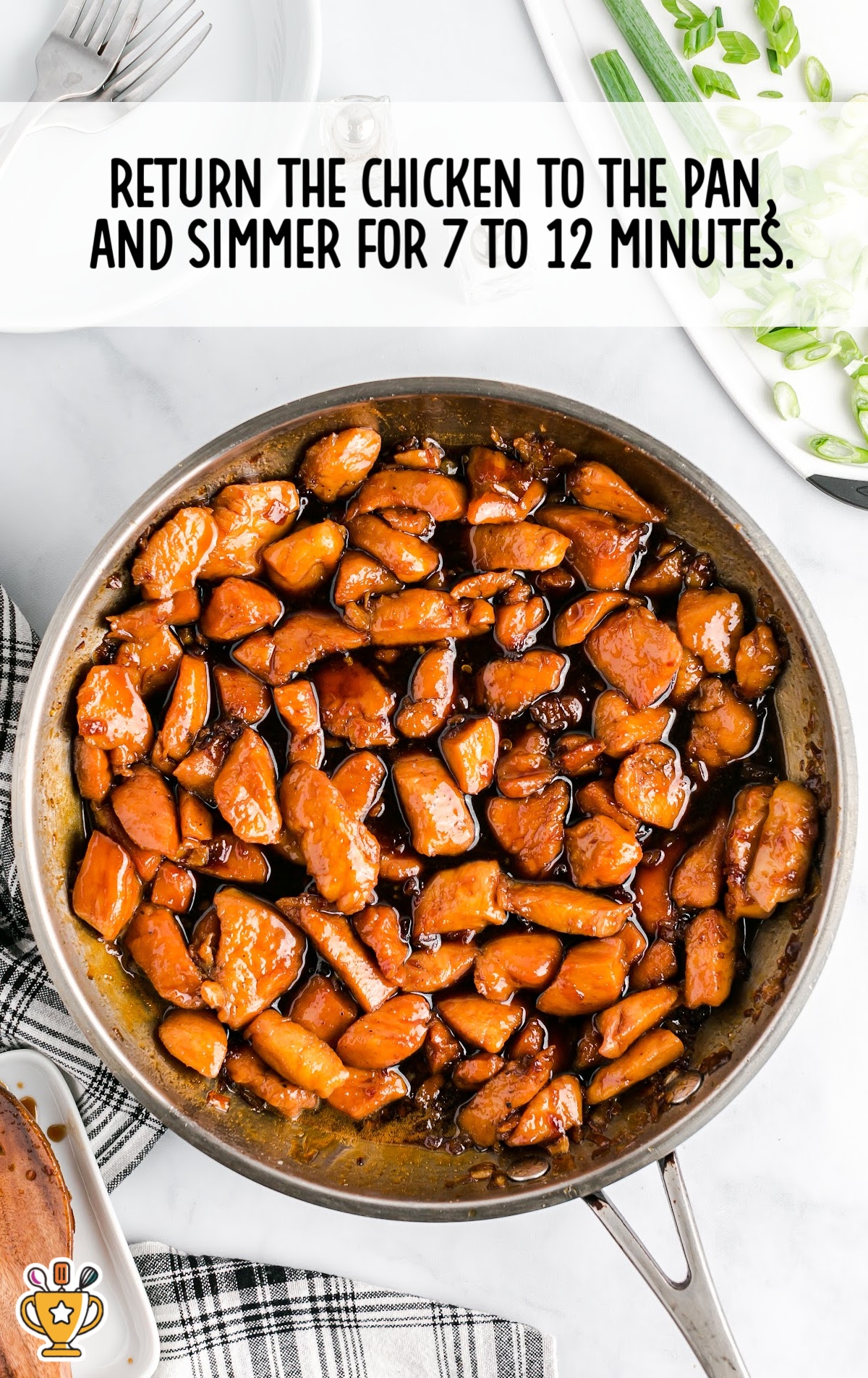 Cooked chicken returned to the skillet and simmering in thickened sauce until fully glazed and flavorful.