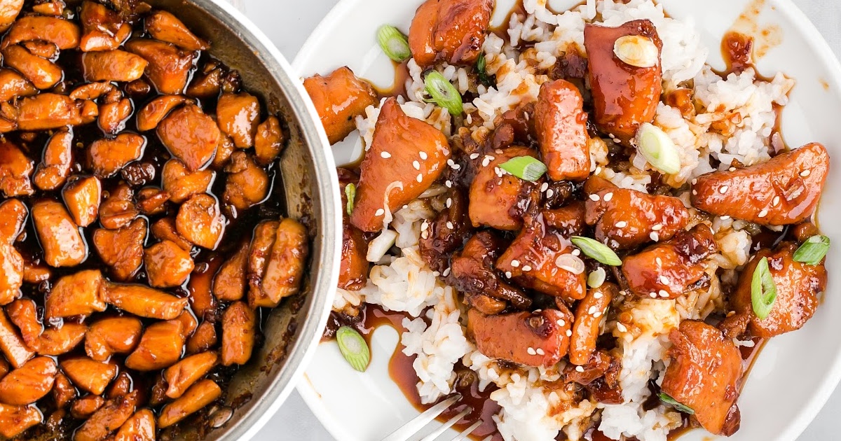 Overhead view of skillet with glossy honey garlic chicken next to a plate served with rice and green onions.