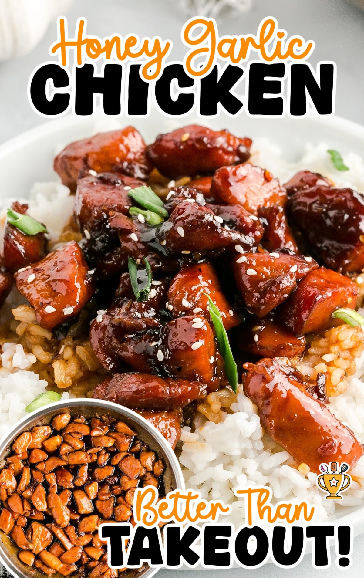 Close-up shot of glossy honey garlic chicken chunks resting on a bed of fluffy white rice, garnished with green onions and sesame seeds.