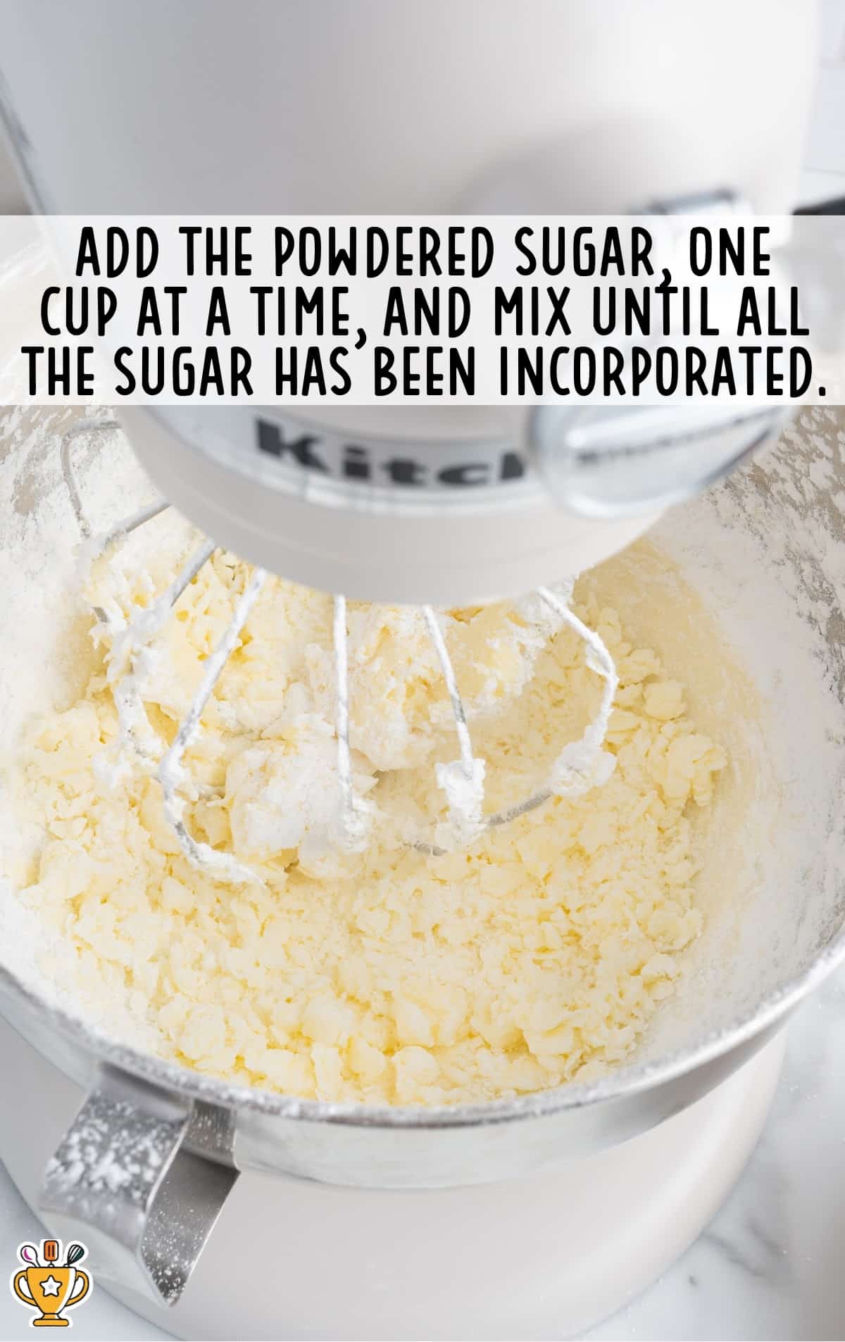 Powdered sugar added to butter in a stand mixer, blending until fully incorporated for lemon buttercream frosting.