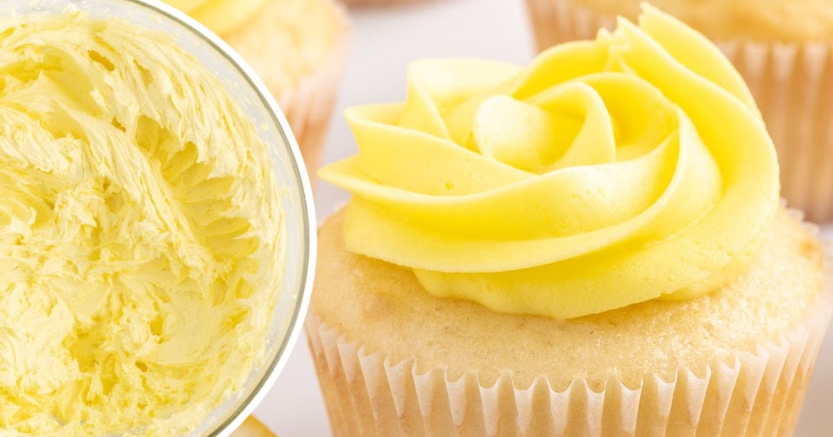 Creamy lemon buttercream frosting in a glass bowl next to unfrosted cupcakes, showing the fluffy whipped texture.