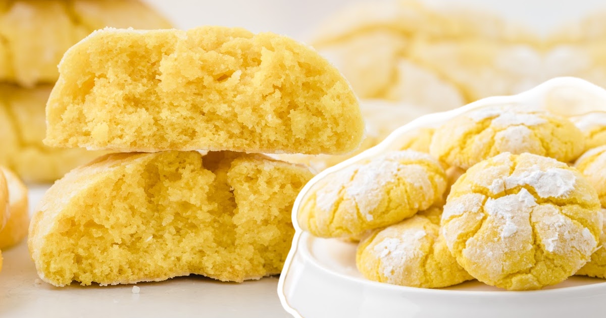 Soft lemon crinkle cookies shown halved to reveal texture, next to a bowl of full cookies coated in powdered sugar.