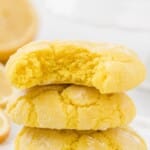 Flat lay of labeled ingredients including flour, sugar, butter, lemon juice, zest, food coloring, egg, and extracts on a white background.