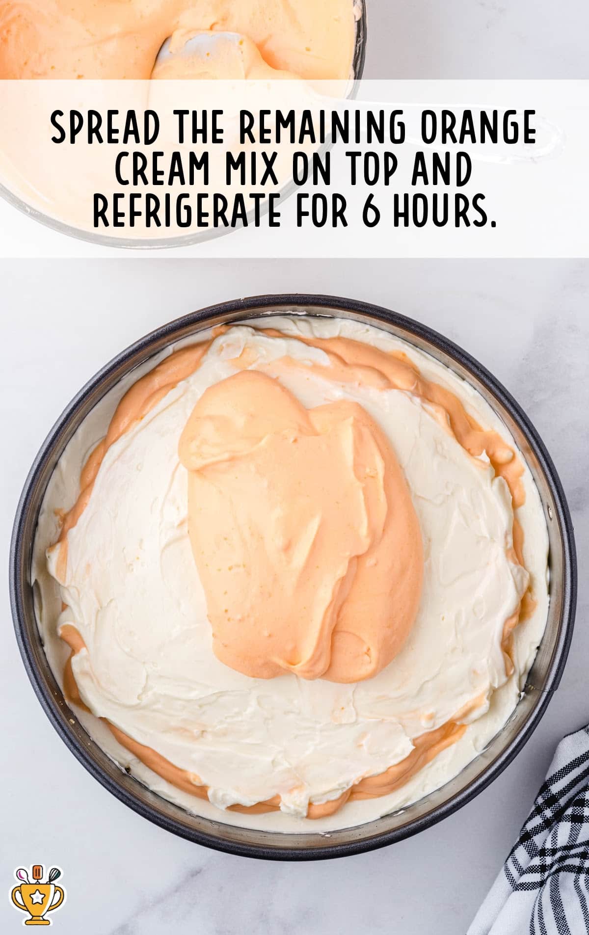 Final cheesecake layer in a springform pan being topped with remaining orange cream mixture, ready to be chilled for setting.