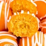 Vertical image of vibrant orange truffles with white drizzle, text overlay highlights they’re made with cake mix and topped with one truffle split in half.