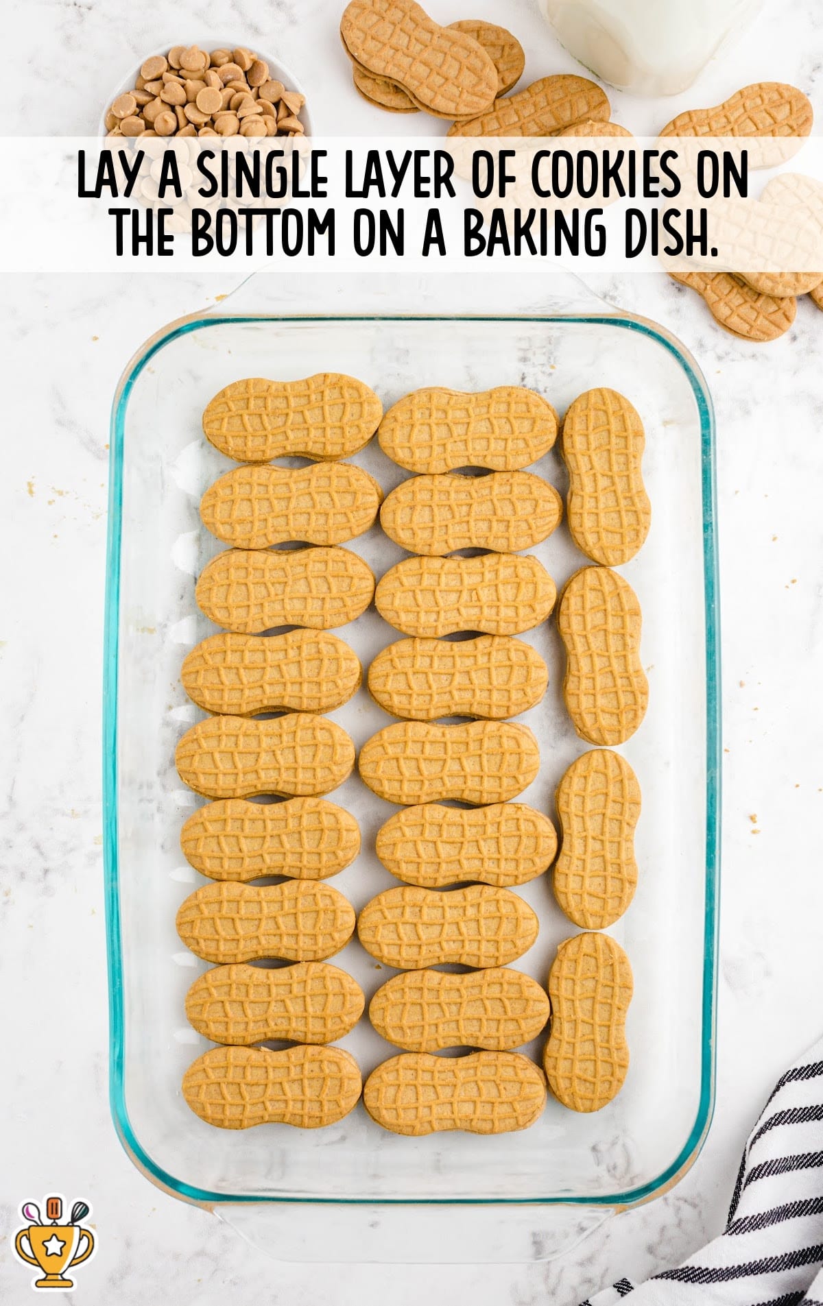Glass baking dish with a single layer of Nutter Butter cookies arranged at the bottom, surrounded by additional ingredients.