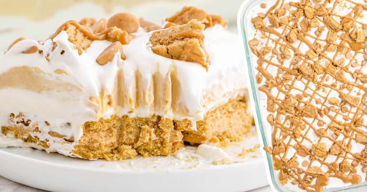 Slice of peanut butter lasagna on a plate with full dessert pan shown beside it, topped with drizzle and cookie pieces.