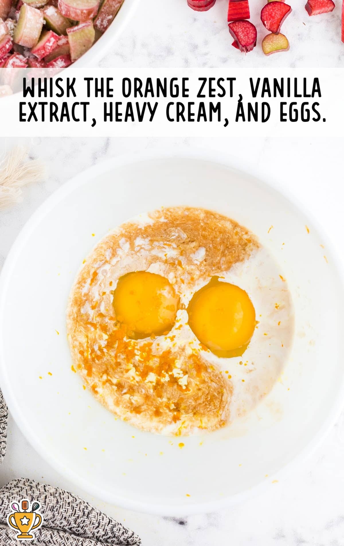 Mixing bowl with eggs, cream, vanilla, and orange zest before being whisked into the custard base for rhubarb pie.