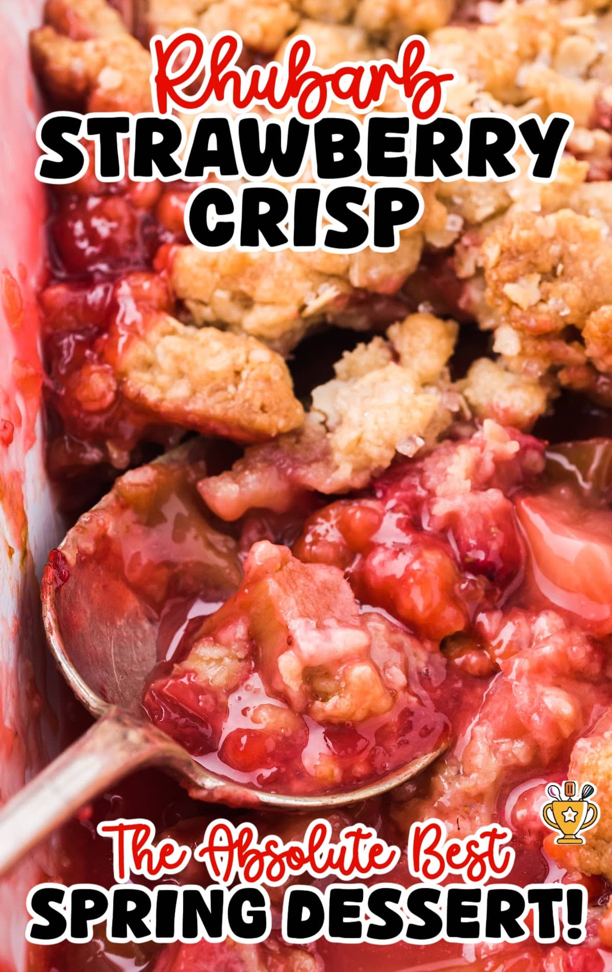 Top-down view of a baking dish filled with rhubarb strawberry crisp, with a spoon scooping out the juicy dessert.