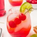 Clear recipe card image of a mason jar filled with a finished Shirley Temple, topped with cherries and a lime, with text overlay showing steps.