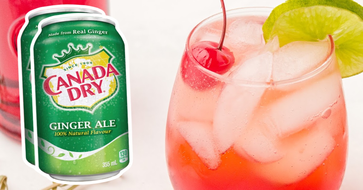 Close-up view of a Shirley Temple drink in a stemless glass, garnished with maraschino cherry and lime wheel on the rim.
