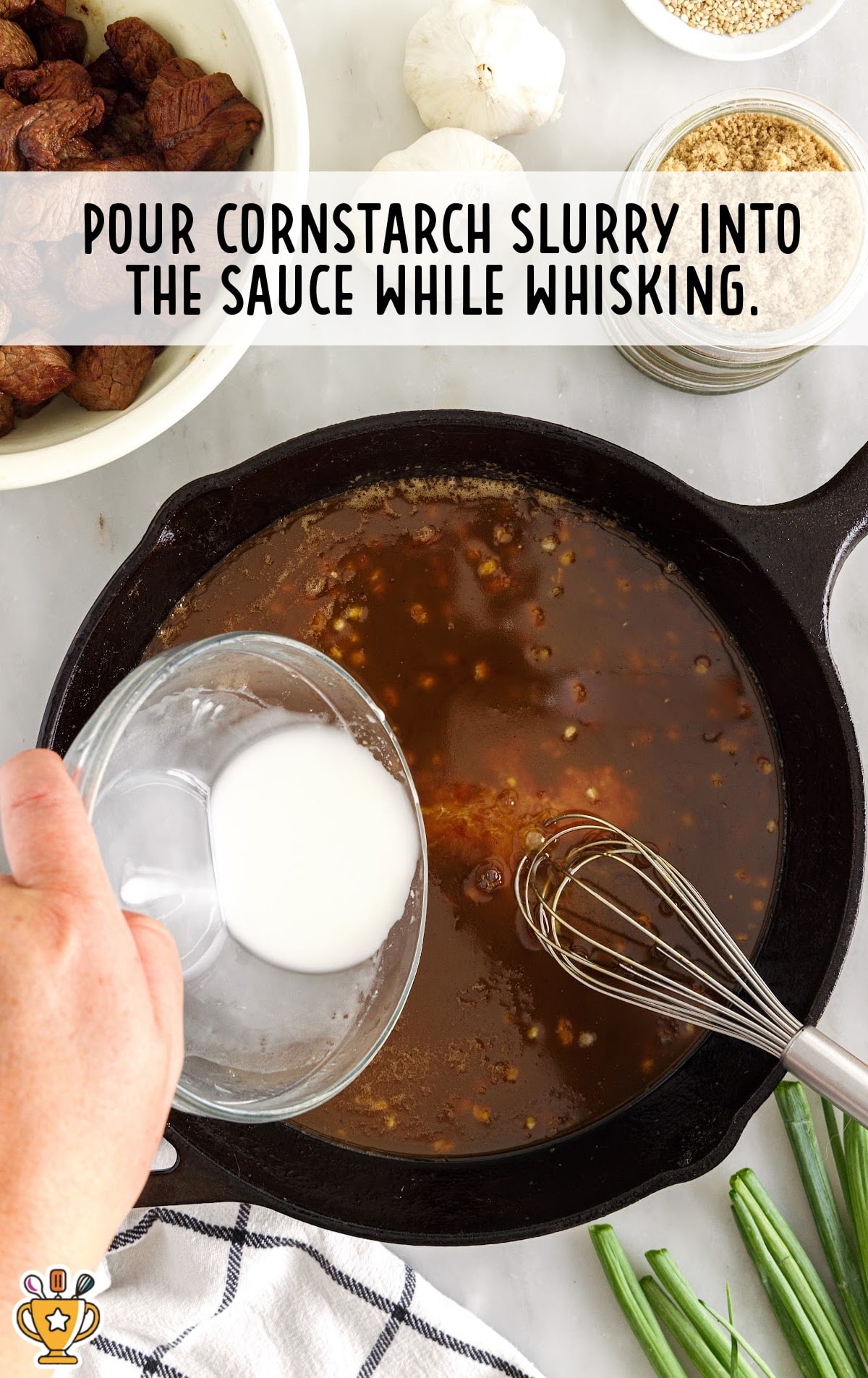 pouring white cornstarch slurry into the dark teriyaki sauce in a cast iron skillet.