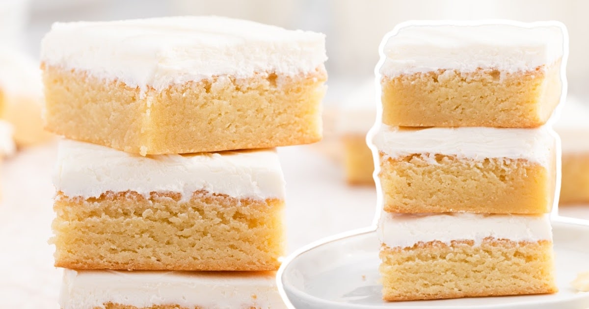 Four frosted vanilla brownies—two stacked and two side-by-side—against a bright background to emphasize the golden texture and rich frosting.