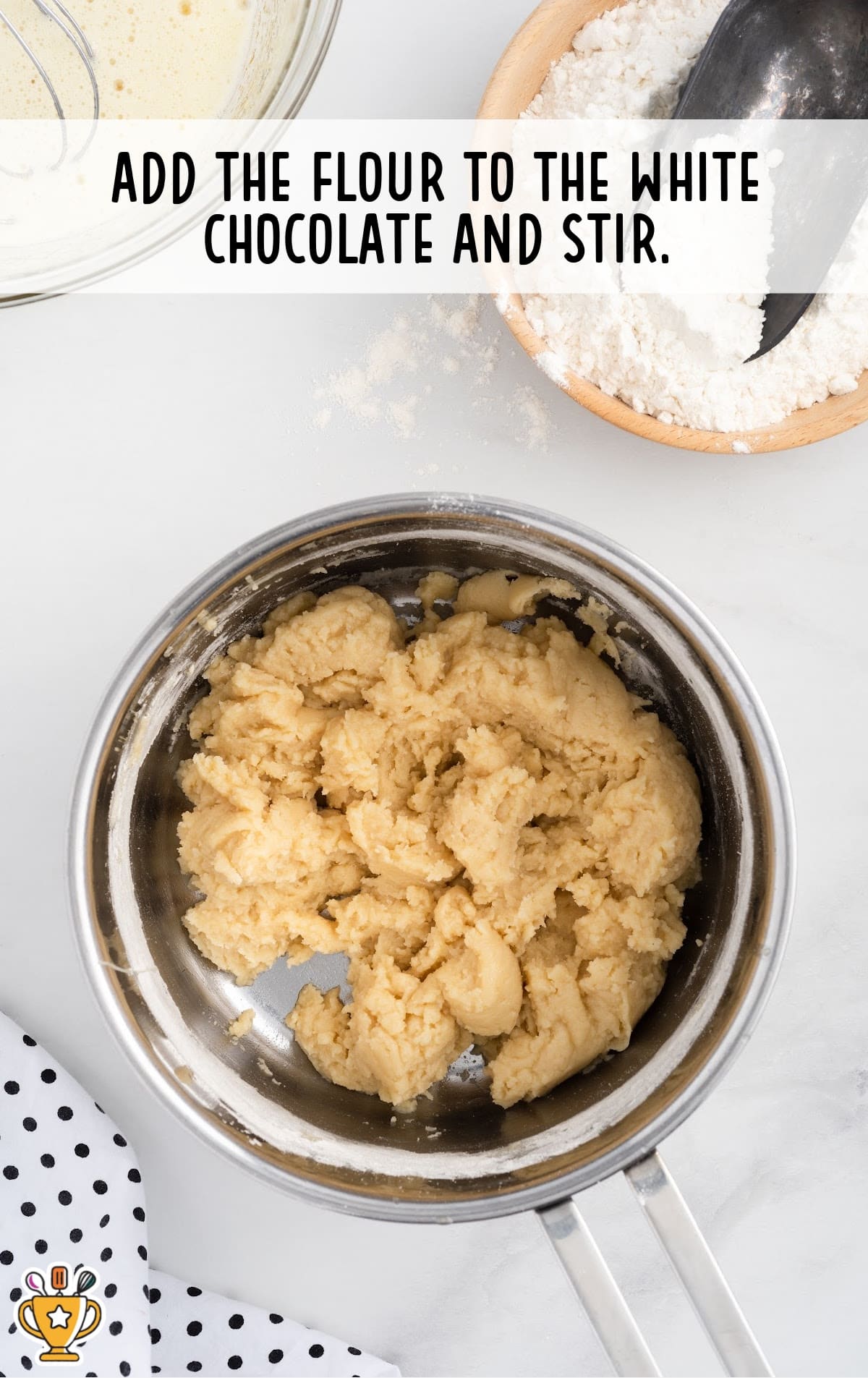 A thick doughy mixture of melted white chocolate and flour in a metal saucepan, ready to be combined with other ingredients.