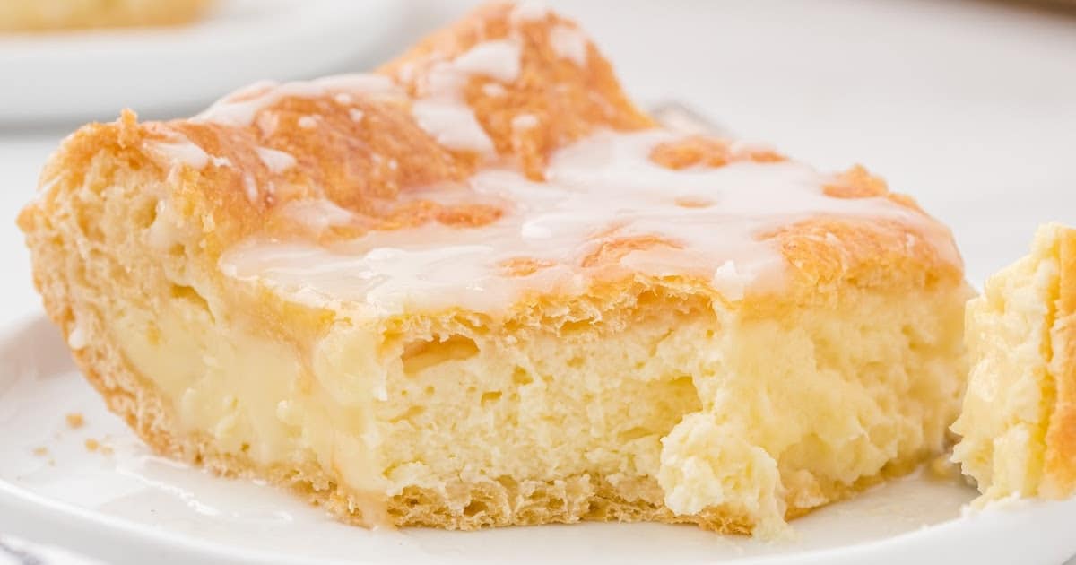 Close-up of a bite taken out of a piece of cheese danish showing soft and fluffy center.
