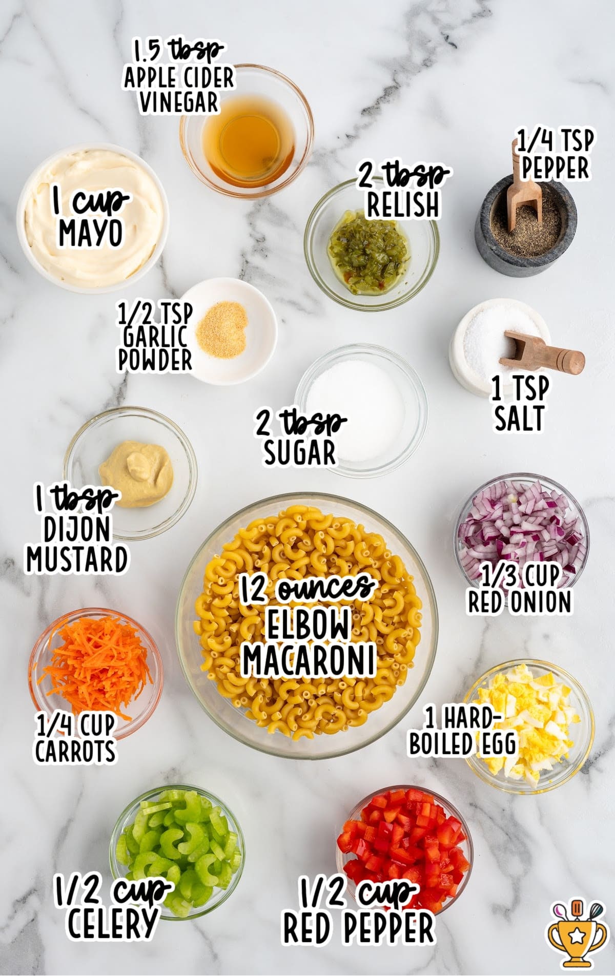 Overhead shot of macaroni salad ingredients including elbow macaroni, mayo, red onion, celery, red pepper, carrots, egg, and seasonings.