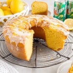 a 7Up Cake with a piece missing on a cooling rack