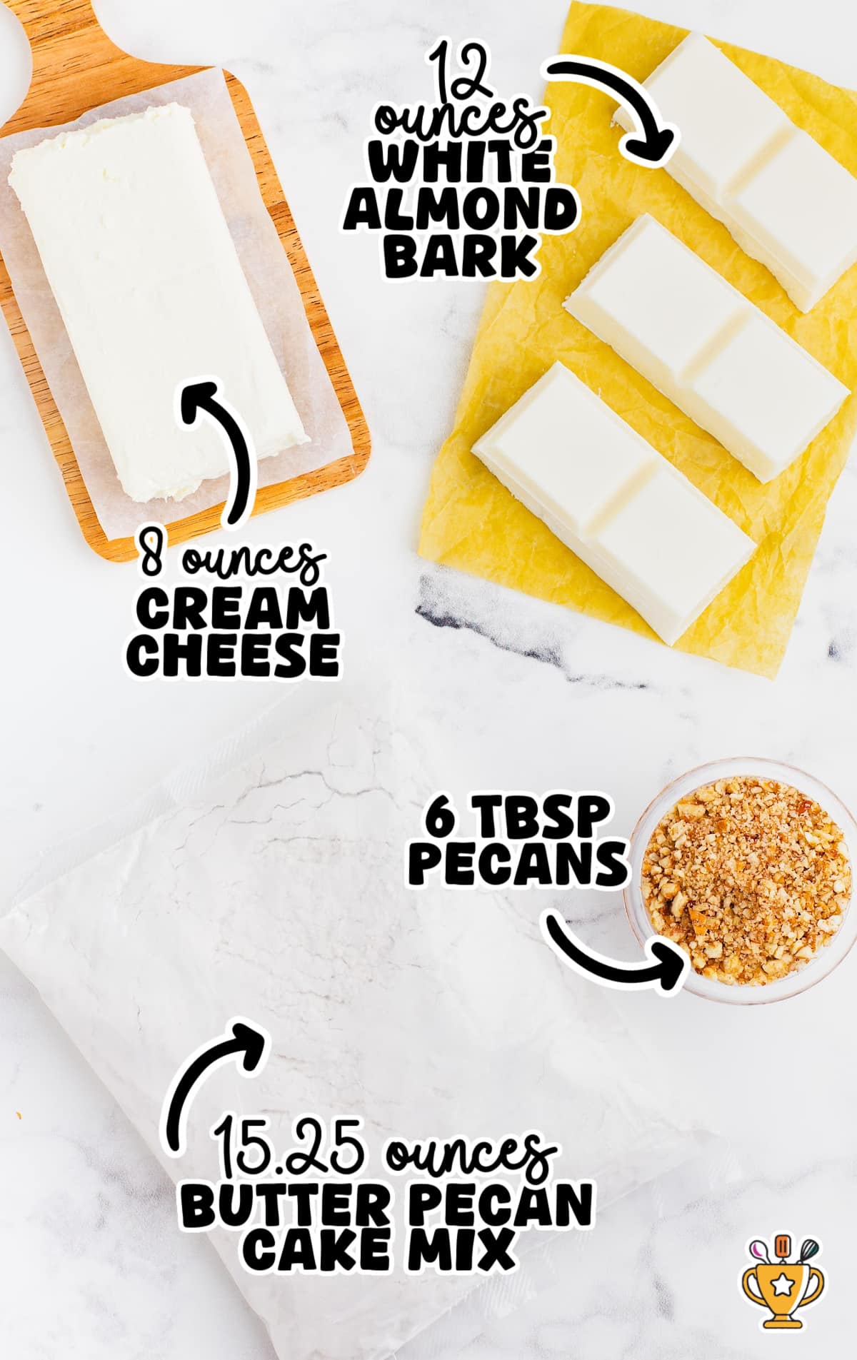 Flat lay of butter pecan cheesecake bites ingredients including a block of cream cheese on a wooden board, white almond bark pieces on yellow parchment, chopped pecans in a small bowl, and a sealed bag of butter pecan cake mix on a white marble surface with handwritten ingredient labels.