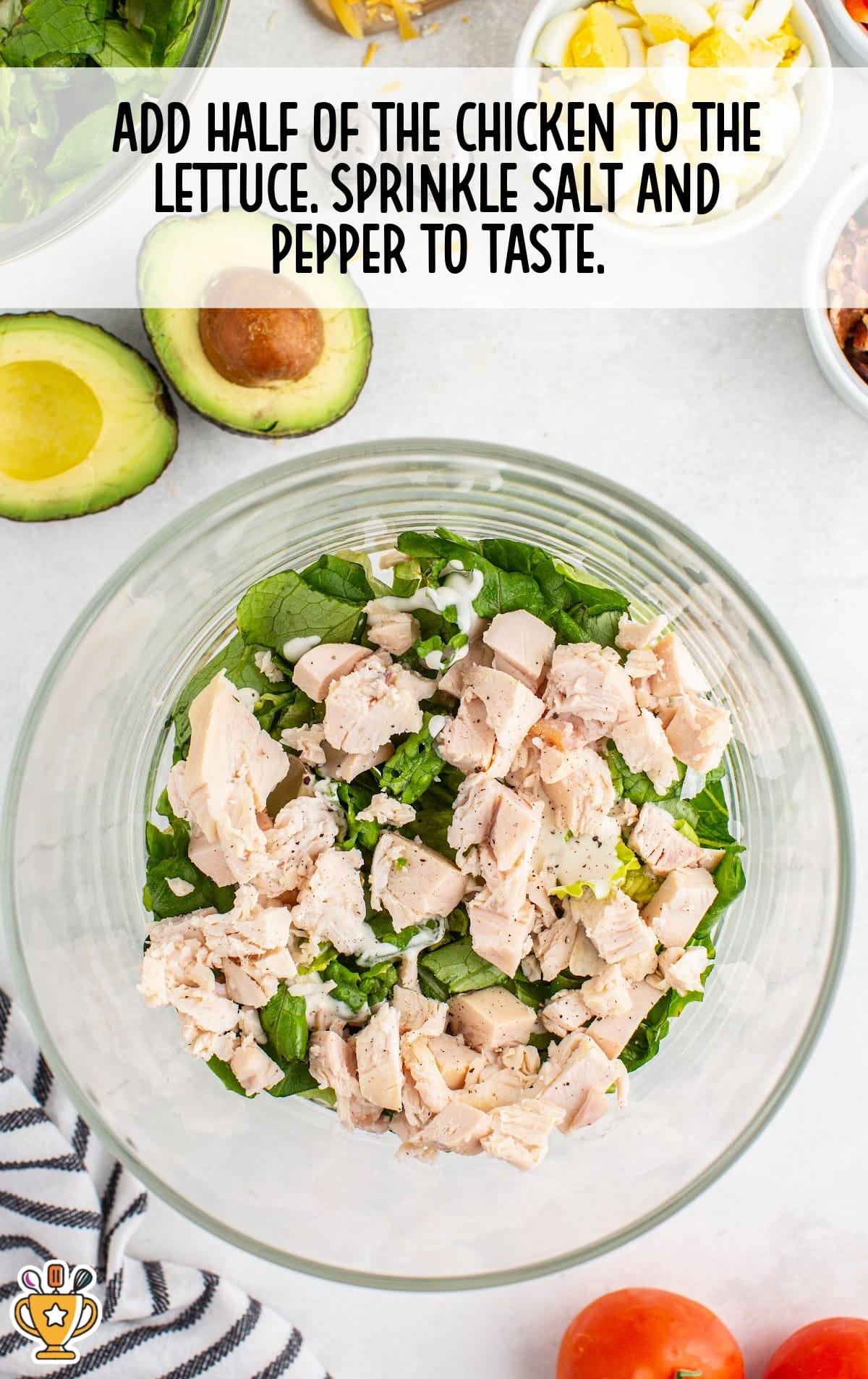 chicken added to the lettuce in a bowl and sprinkled with salt and pepper