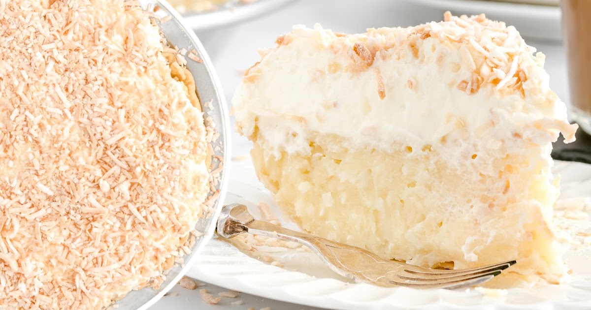 Overhead shot of a whole coconut cream pie on a cooling rack with scattered coconut around.