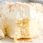 Whole coconut cream pie topped with whipped cream and toasted coconut, styled for Pinterest