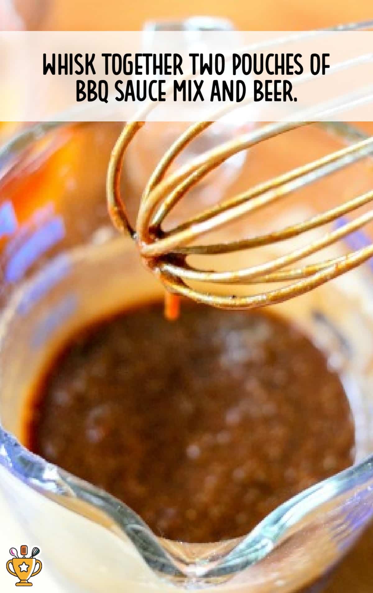 Close-up of a glass measuring cup filled with BBQ sauce and beer being whisked together for the chicken marinade.