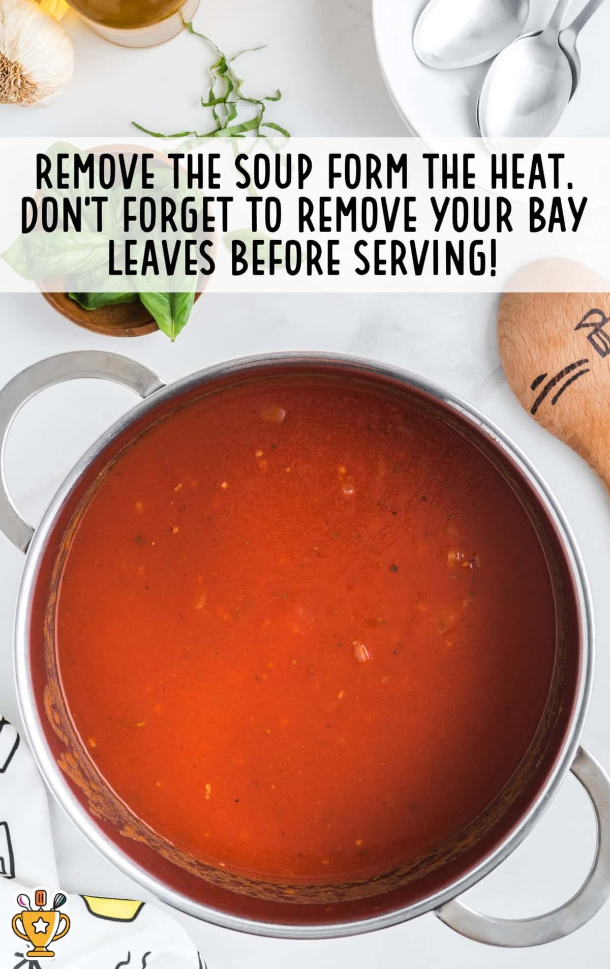 Remove the soup from the heat, with a close-up shot showing a deep pot of smooth tomato soup, garnished with basil leaves.