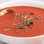 Tomato Soup Recipe in a white bowl with a spoon in it