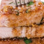 a fork taking a Honey Garlic Pork Chop from a stack