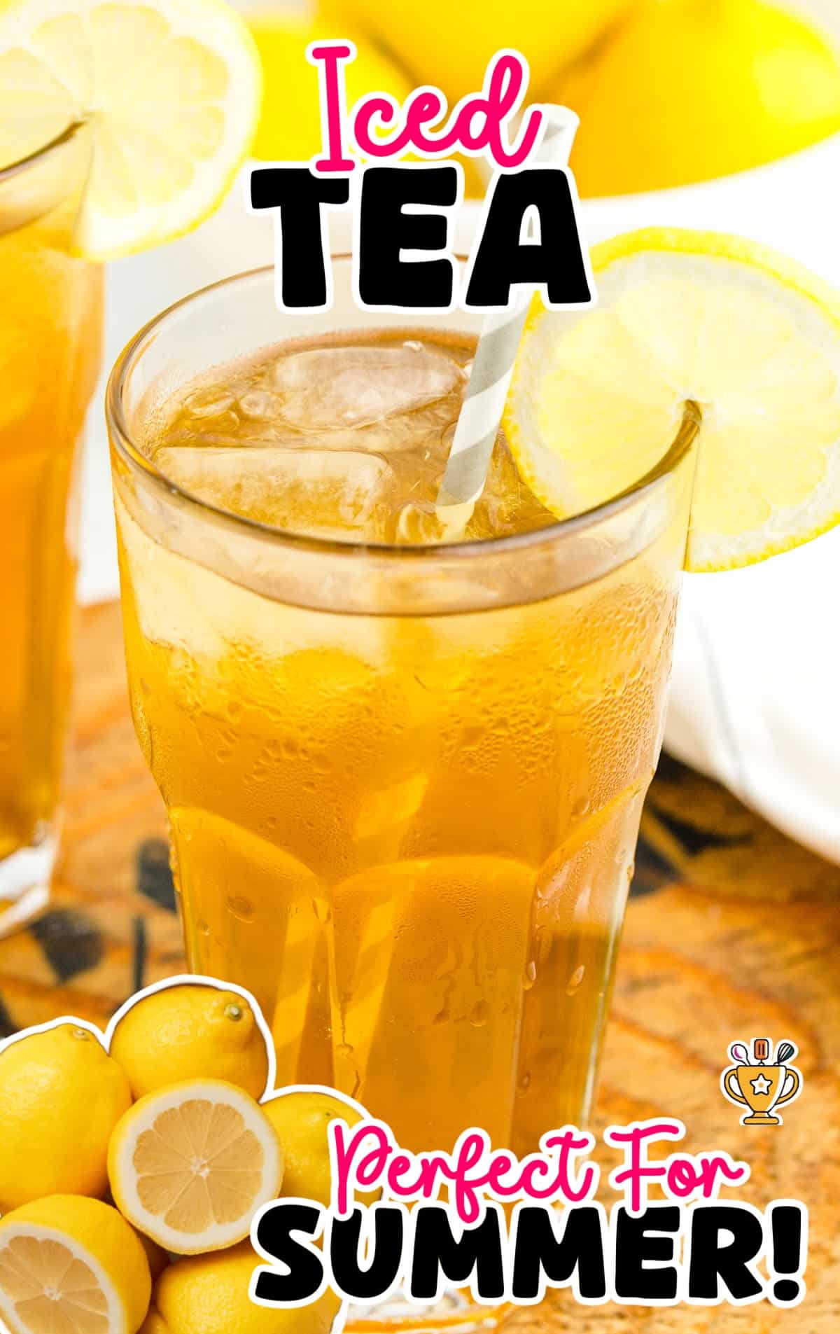 A glass of iced tea with ice and a straw, with fresh lemon slices in the background, against a yellow backdrop.