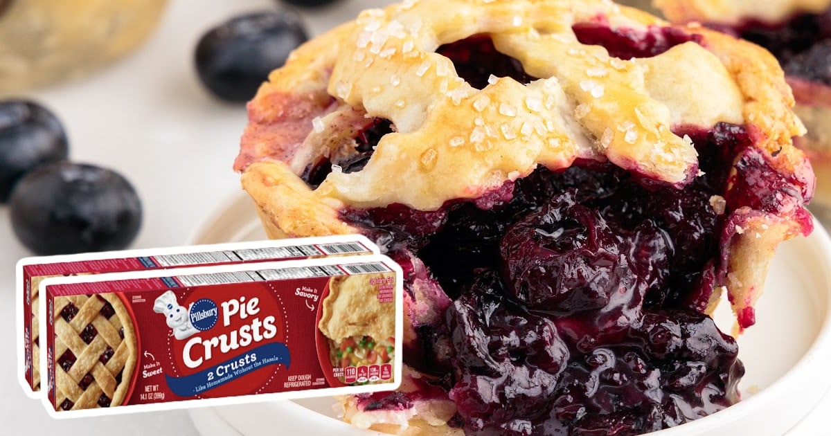 Mini blueberry pie on a white plate with a Pillsbury Pie Crusts box, showing the flaky crust and rich blueberry filling.