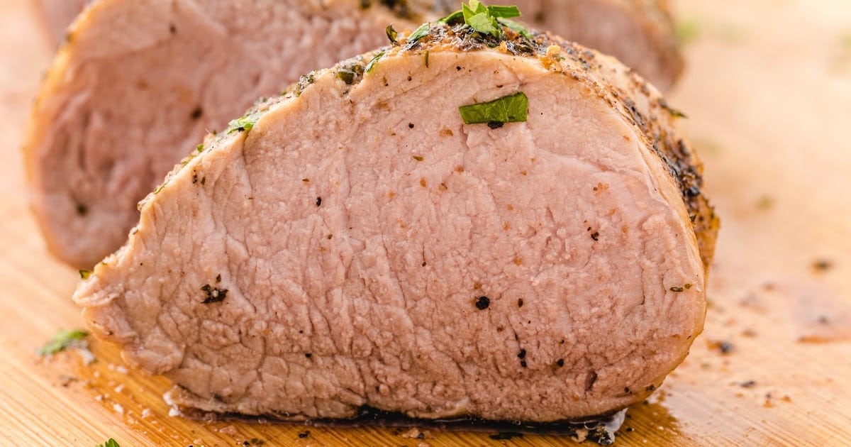 a close up photo of Pork Tenderloin on a wooden board