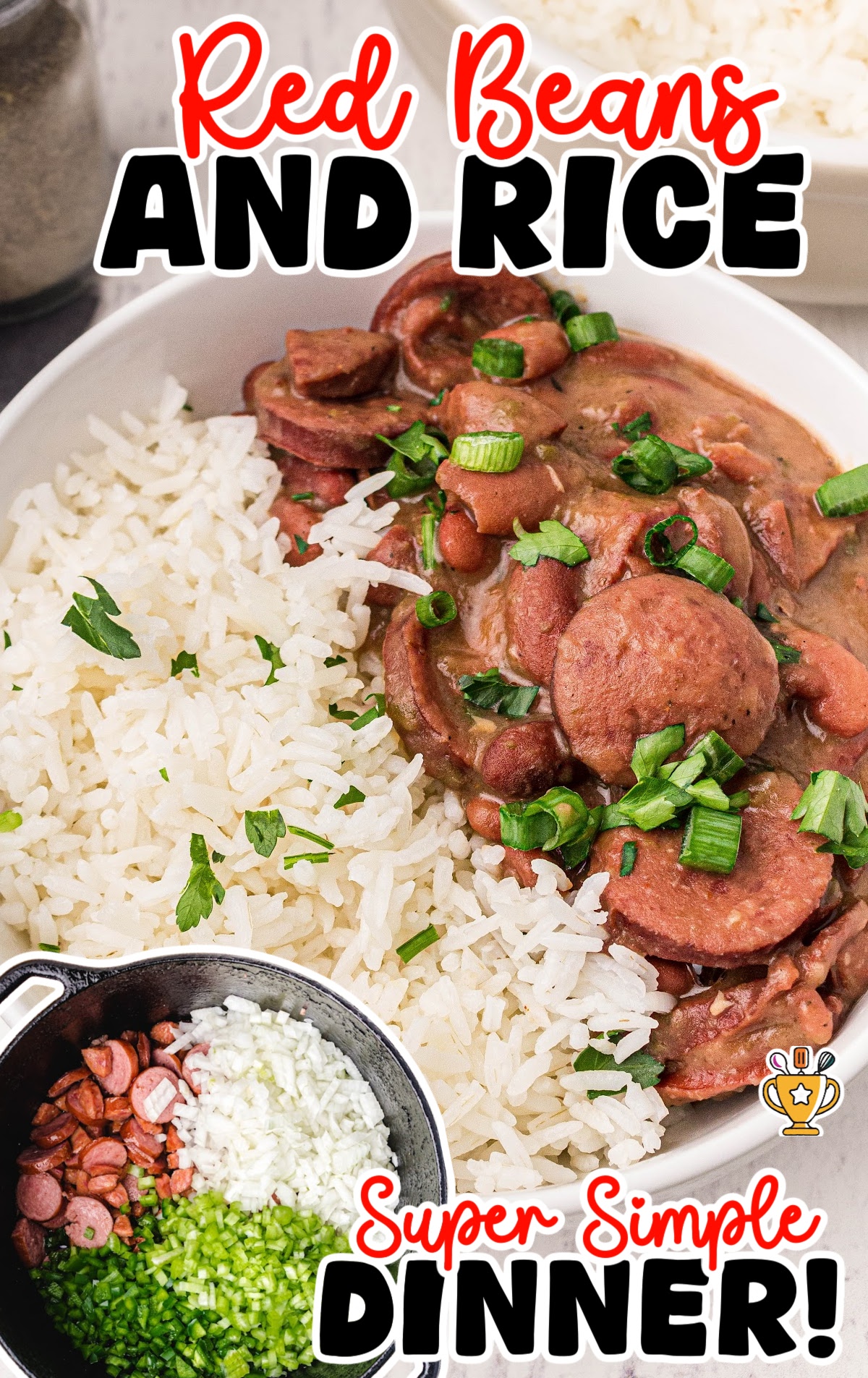 Close-up of a hearty bowl of red beans and rice, topped with sliced sausage and chopped green onions on a white wood surface.