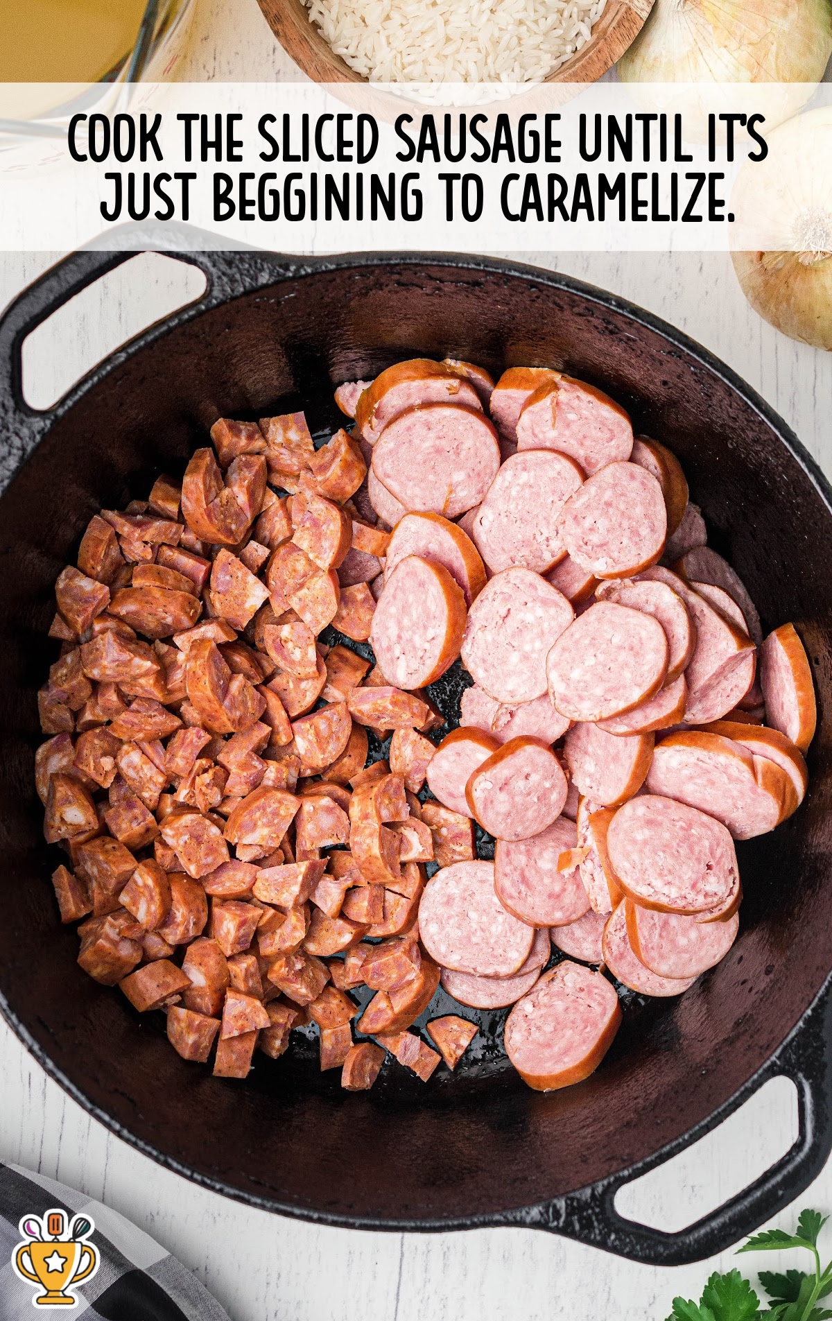 Sliced and diced andouille and smoked sausage cooking in a cast iron skillet until just starting to brown.