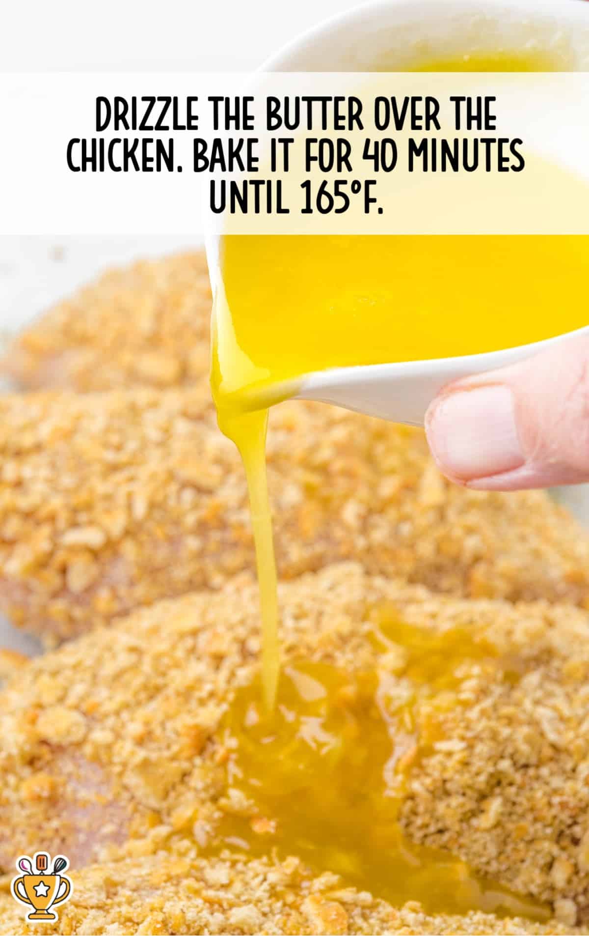 a hand holding a small bowl drizzling the butter over the chicken