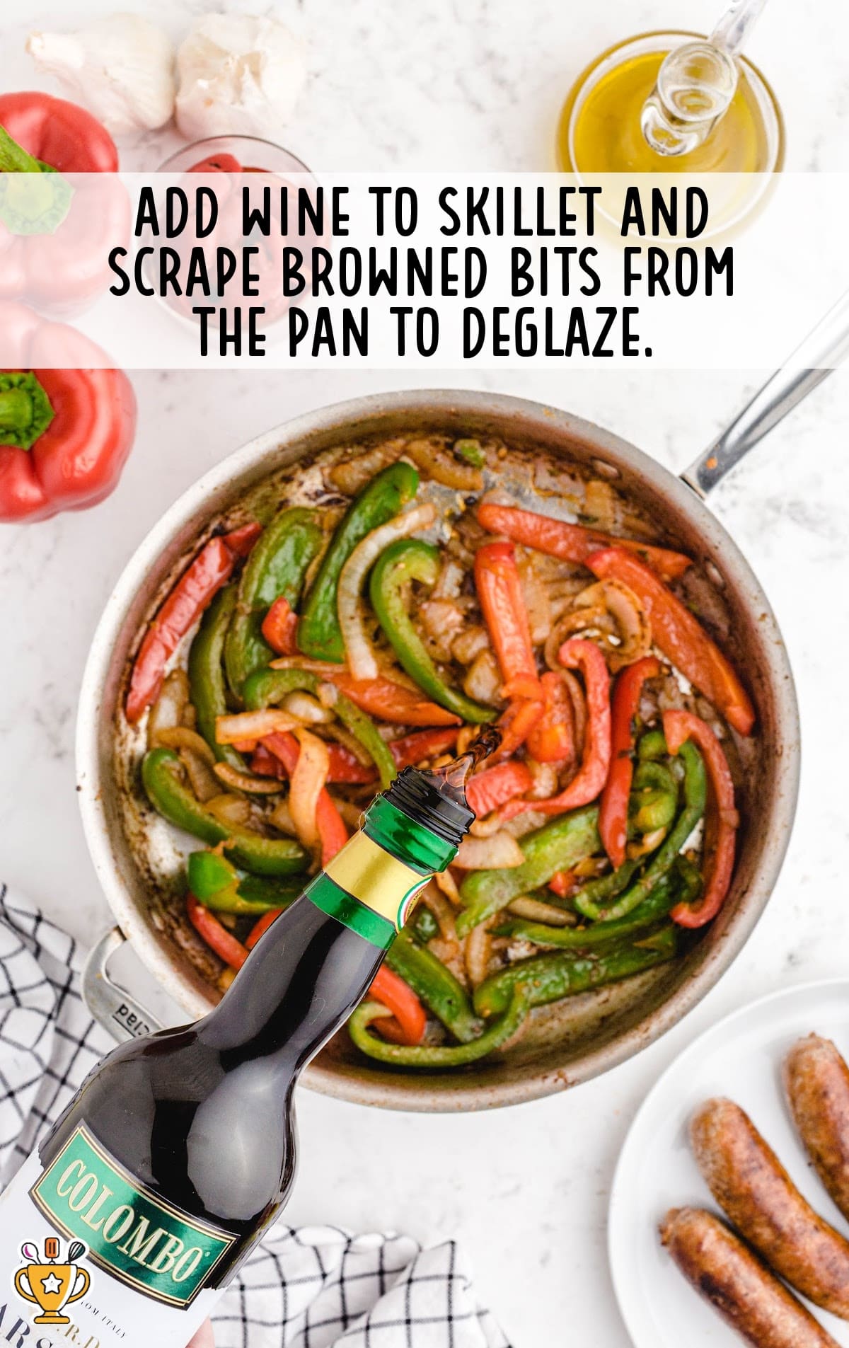 A skillet with sausages cooked and sliced into bite-sized pieces, mixed with the cooked bell peppers and onions. The dish has a rich, savory look as the ingredients meld together.
