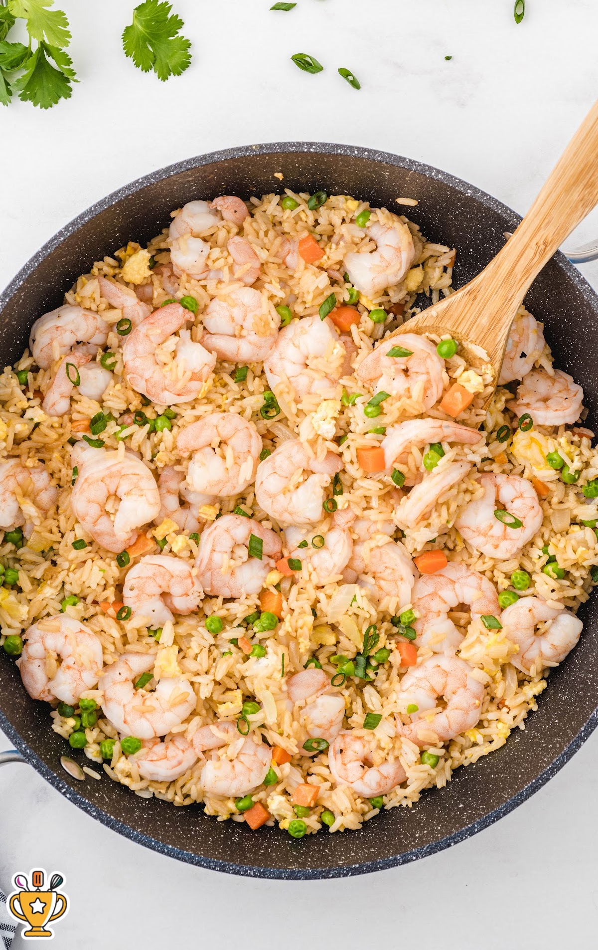 Shrimp Fried Rice in a skillet with a wooden spoon in it