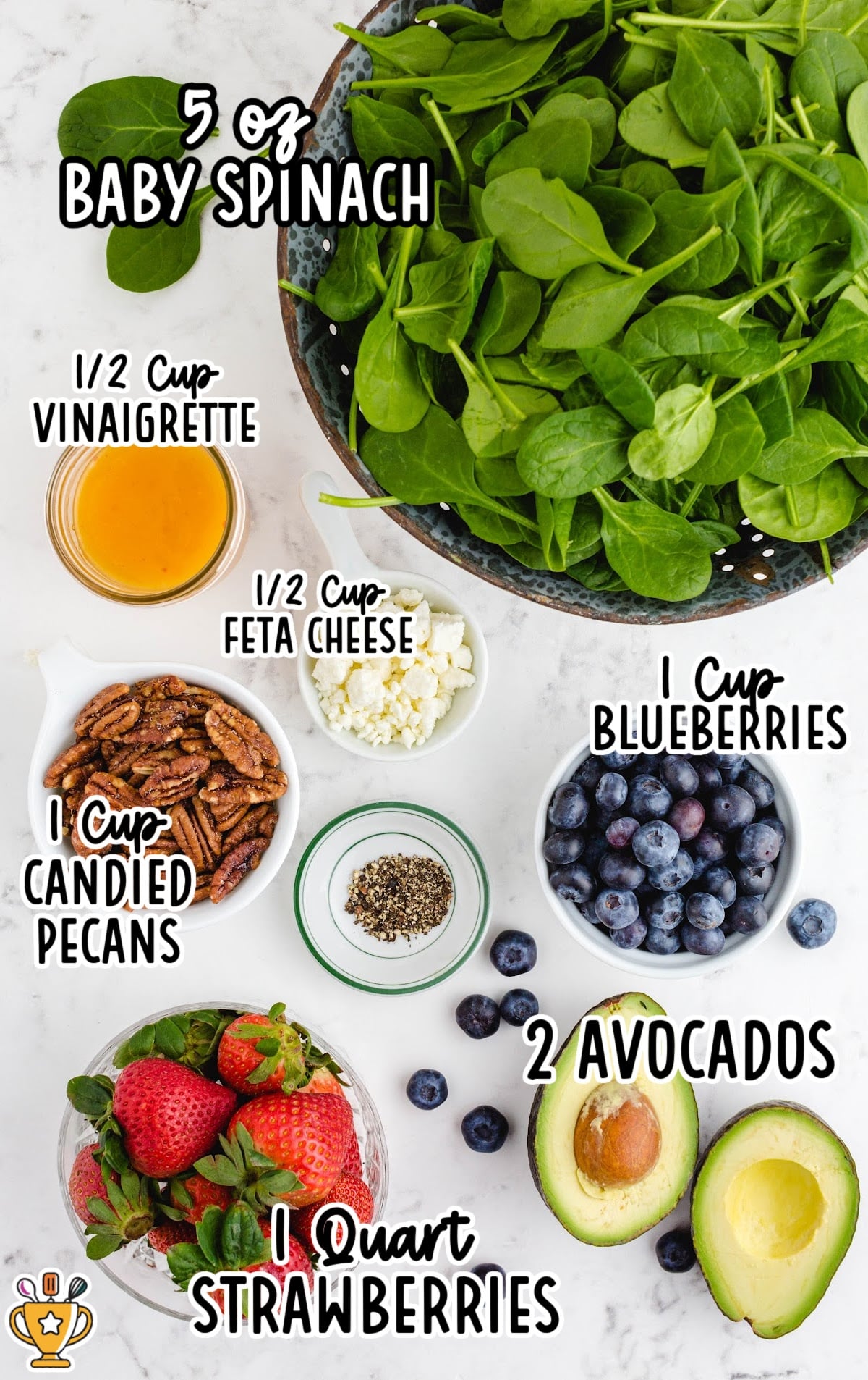 A collection of ingredients for a strawberry spinach salad, including fresh spinach, strawberries, feta cheese, candied pecans, avocado, and blueberries arranged neatly in bowls.