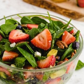 A recipe card with ingredients and preparation steps for a fresh and delicious strawberry spinach salad, with all essential ingredients displayed clearly.