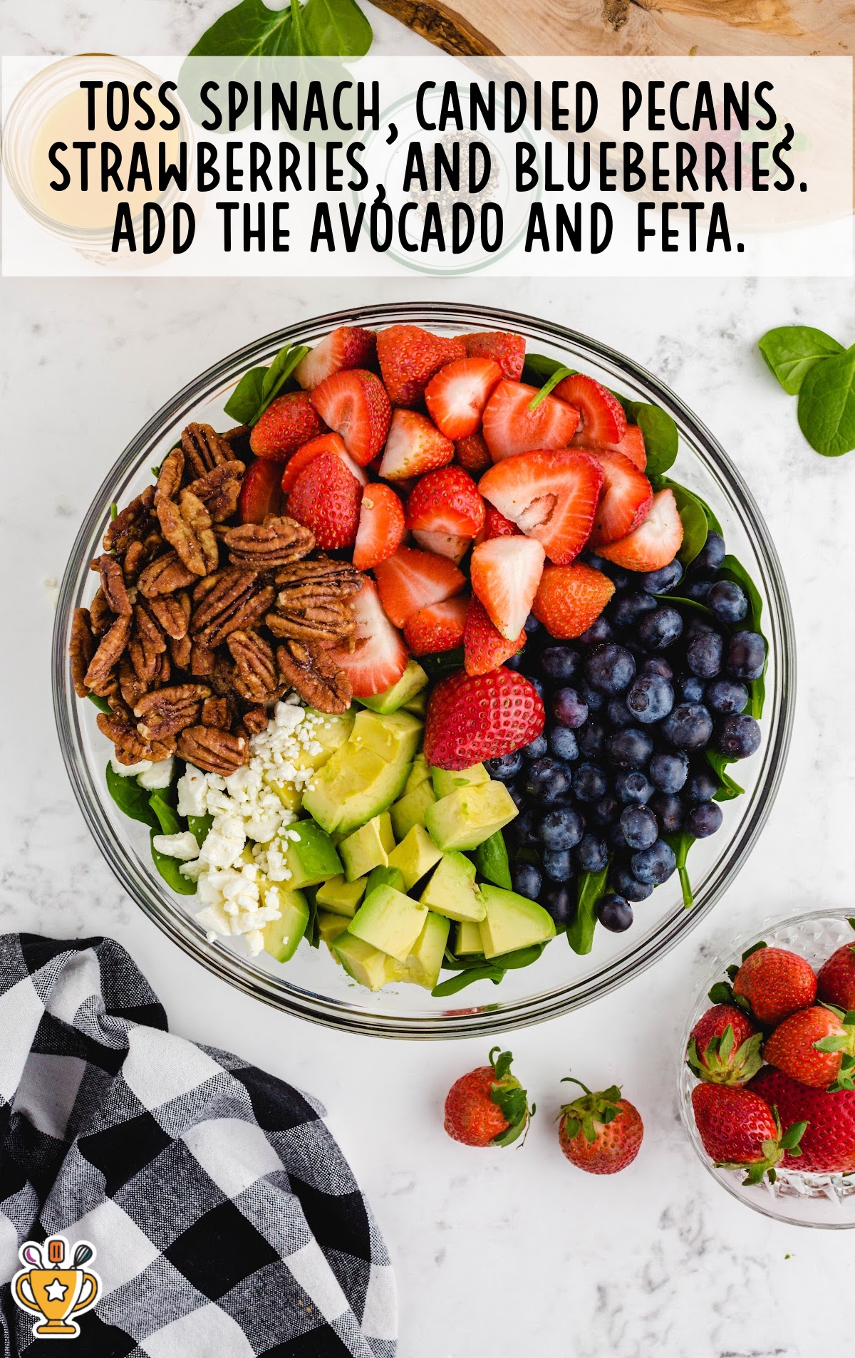 A photo showing the first step of preparing the strawberry spinach salad, with ingredients being added to a mixing bowl.