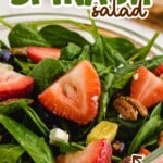 A styled photo of a strawberry spinach salad, perfect for a Pinterest pin, with fresh fruit and greens.