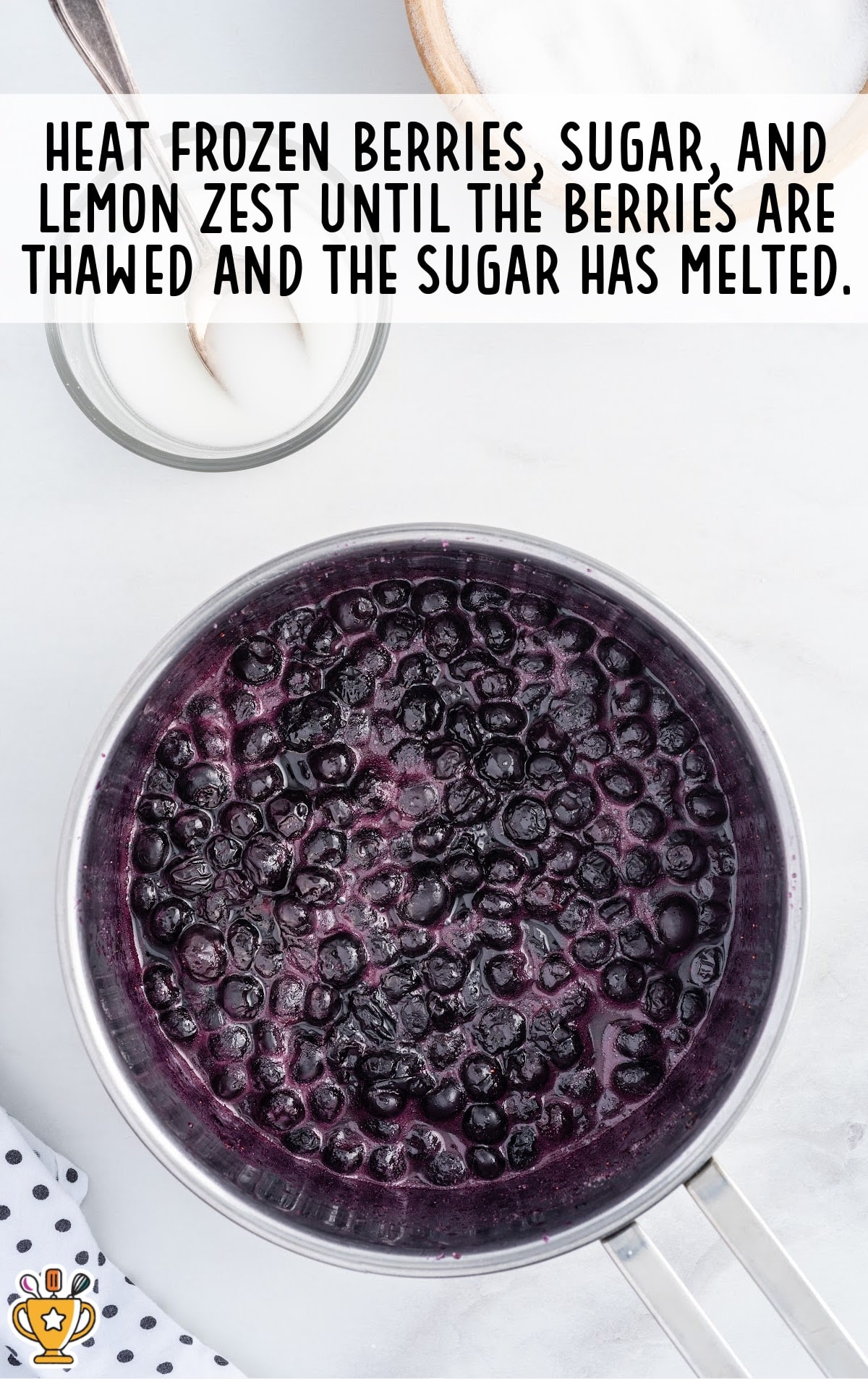 heating the frozen berries, sugar and lemon zest in a pan