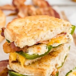 Overhead view of sandwich ingredients including jalapeños, bacon, bread, cheese, green onions, garlic, and cream cheese labeled with quantities.