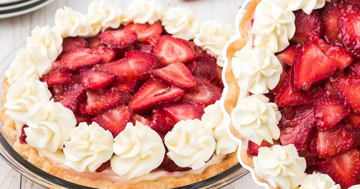 A full strawberry cream cheese pie with a rich layer of strawberries, topped with whipped cream, and set in a pie dish.