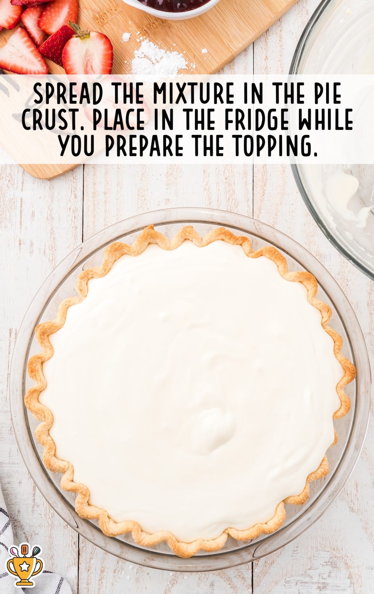 The pie filling has been spread into the baked pie crust and is ready to be chilled in the fridge.
