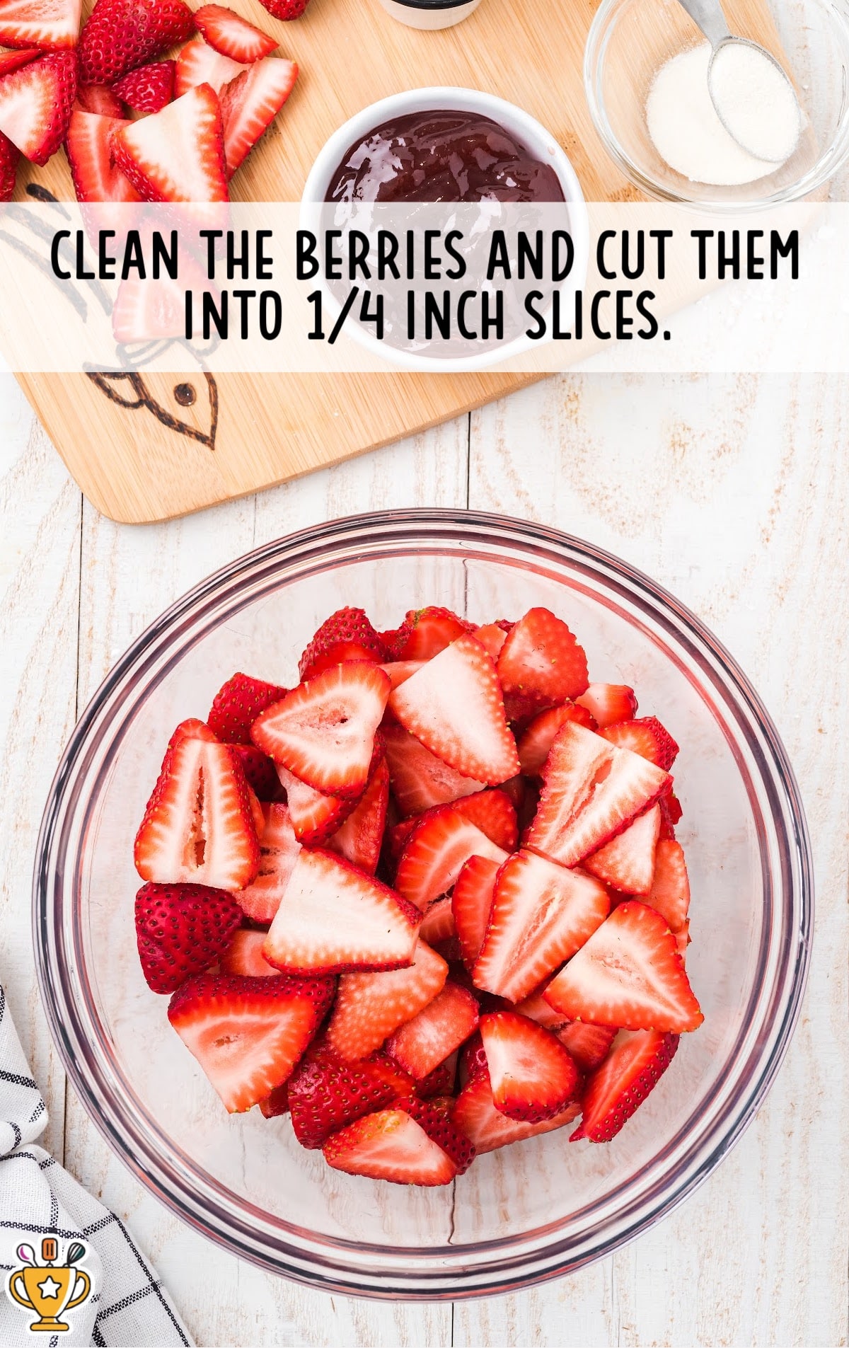 Freshly sliced strawberries are being prepared to be added as the topping for the strawberry cream cheese pie.