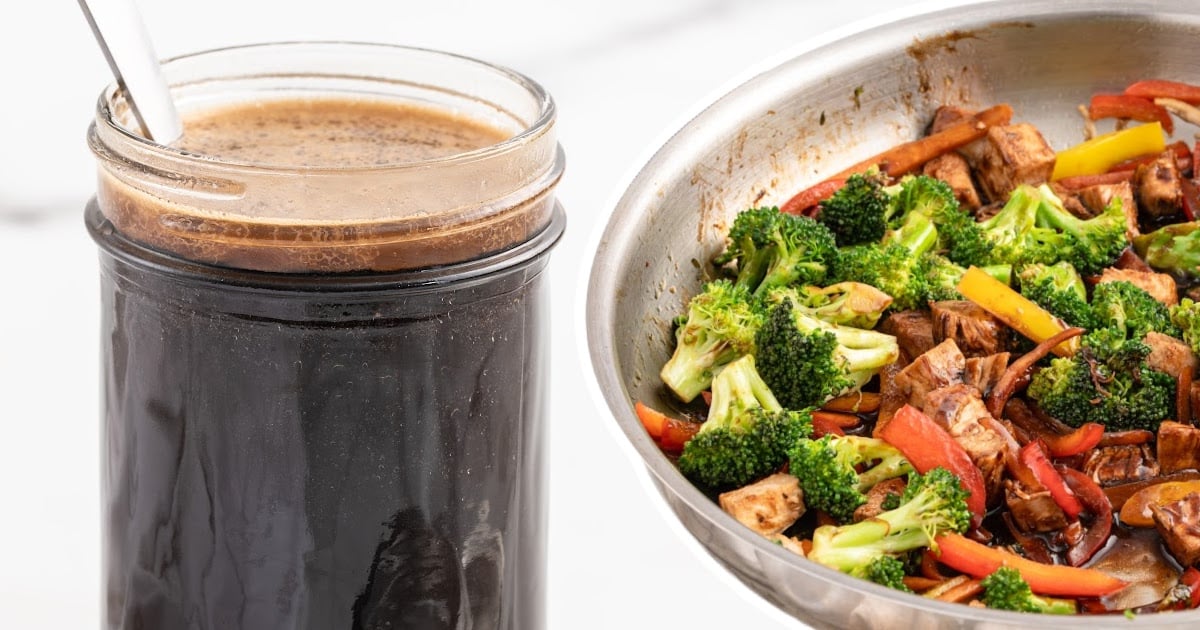 A glass jar filled with dark brown stir fry sauce with a spoon inside, next to a stainless steel bowl containing a colorful vegetable stir fry with broccoli, red and yellow bell peppers, tofu, and carrots coated in sauce.
